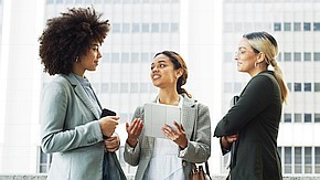 Three young business women with a tablet computer